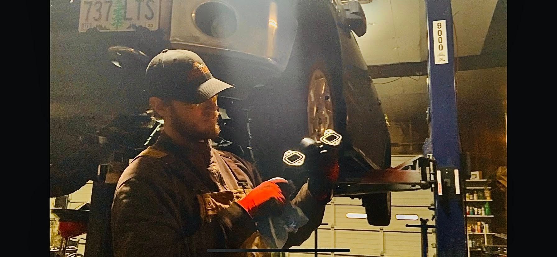 Technician Performing Suspension Repair On Vehicle Lift | Frontier Automotive