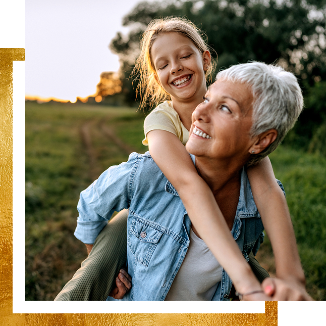 A girl and her grandmother playing piggy back.