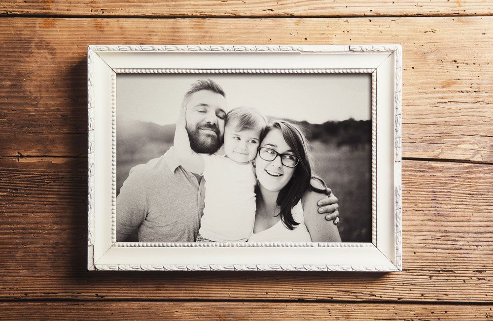 A Black and White Photo of A Family in A Frame on A Wooden Table — The Framer In Taree, NSW
