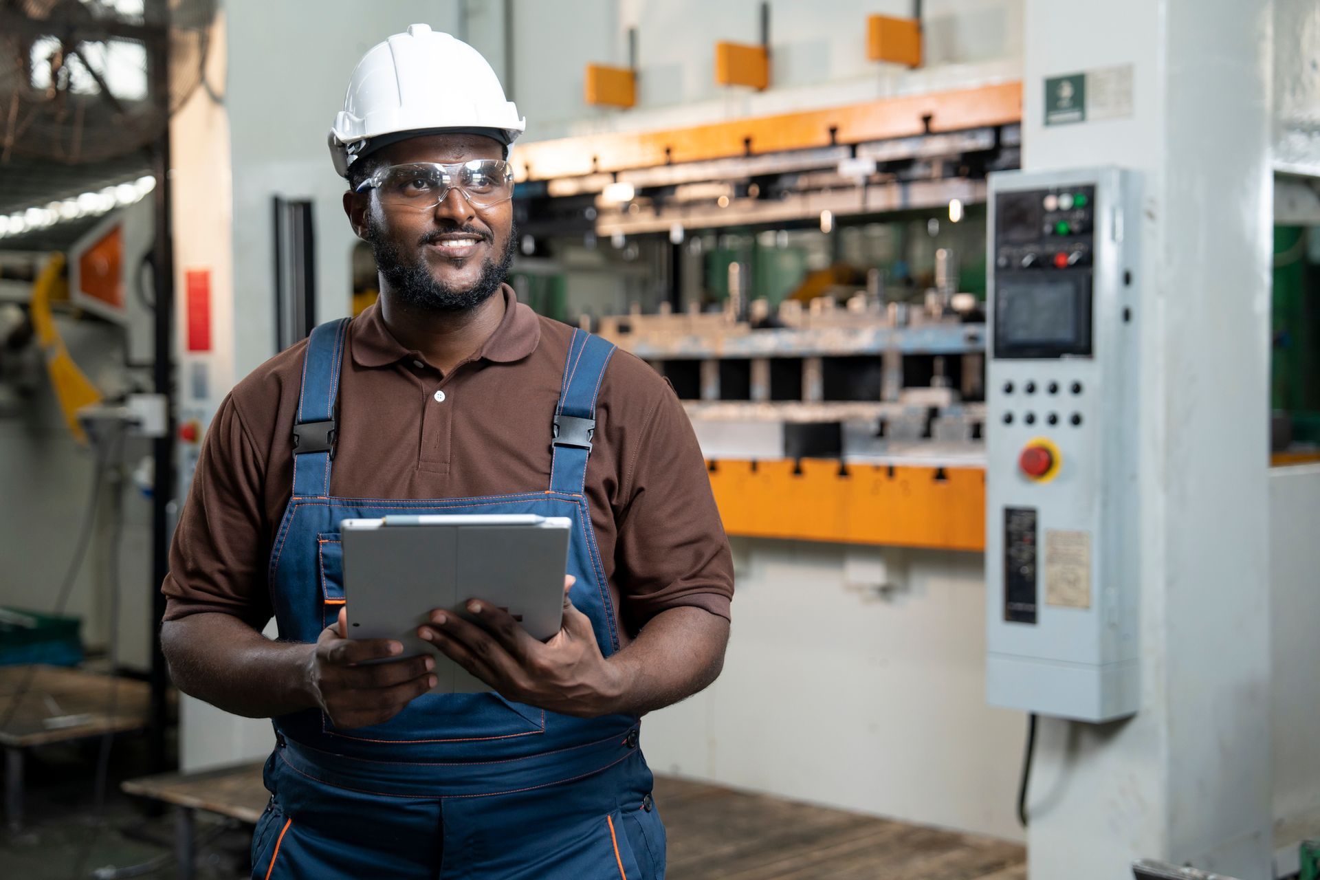 Engineer working in a production line and examining automated machinery.