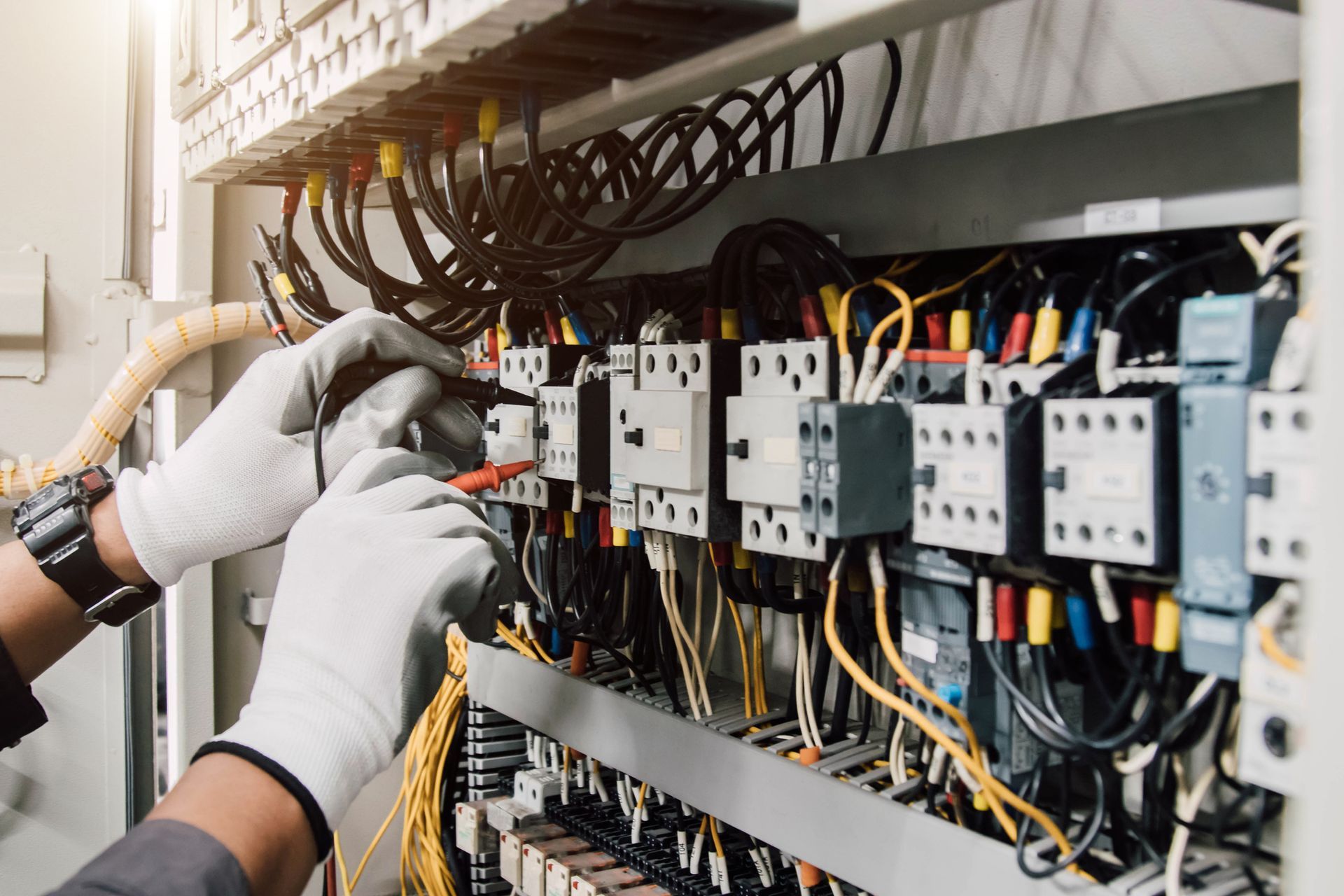Electrician engineer tests electrical installations and wires on relay protection system.