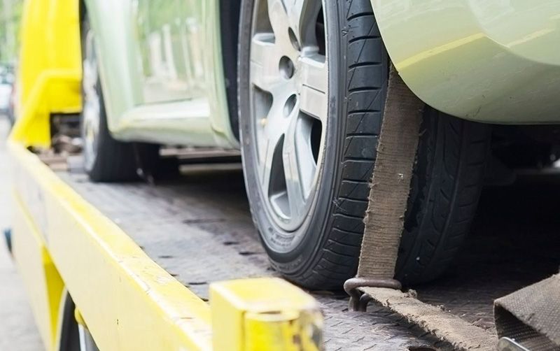 A car is being towed by a tow truck.