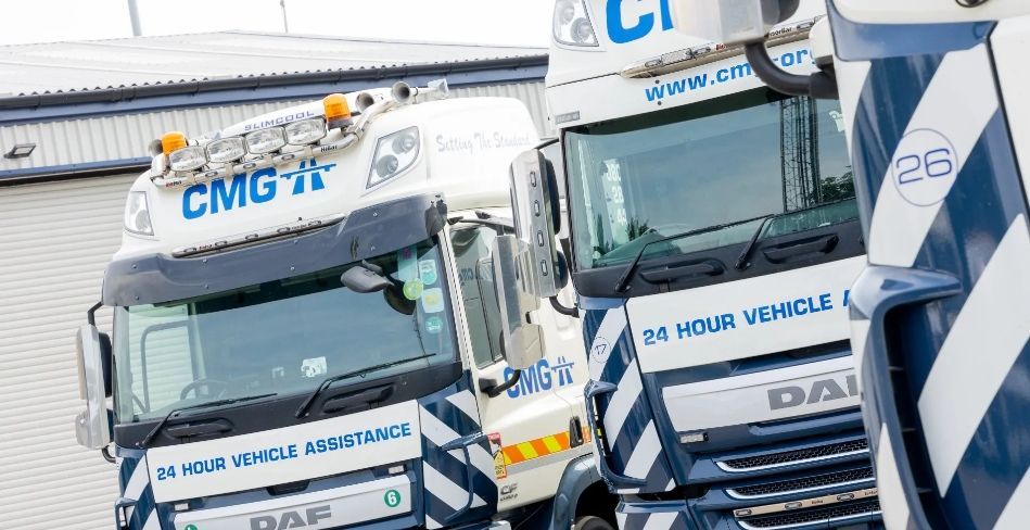 Two trucks are parked next to each other in front of a building.