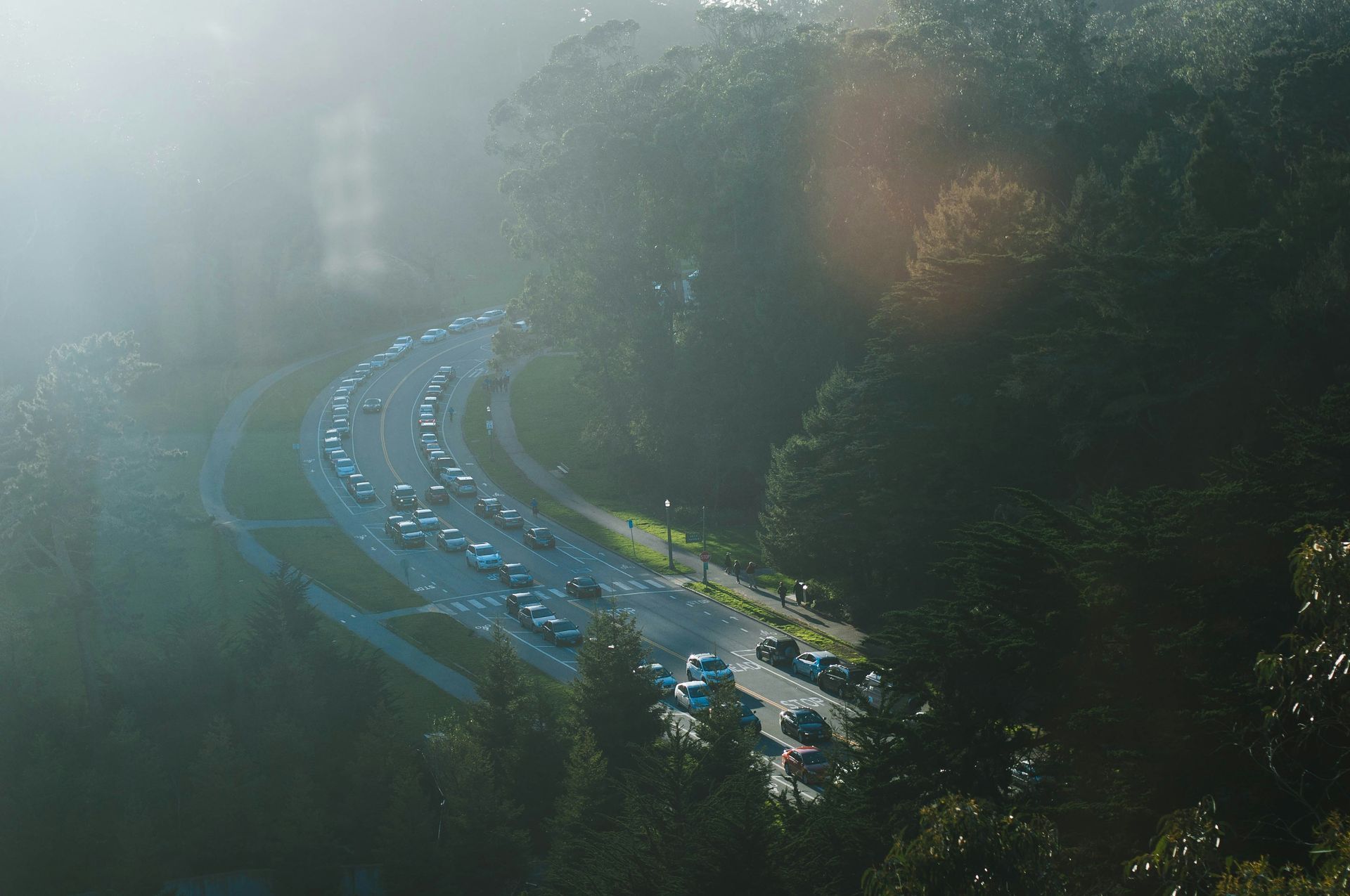 An aerial view of a highway surrounded by trees on a foggy day.