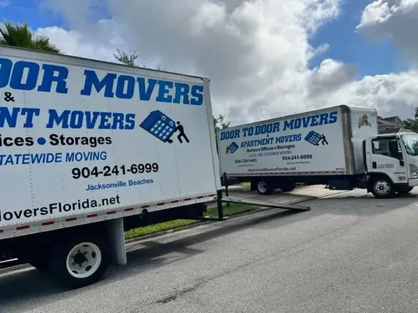 Movers loading furniture into a truck while a couple watches.