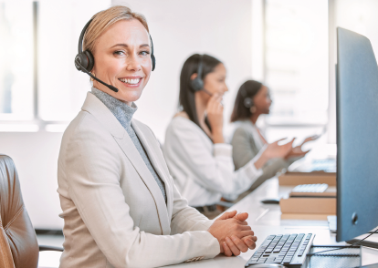 Woman with headphones, laptop, and microphone; podcast recording.