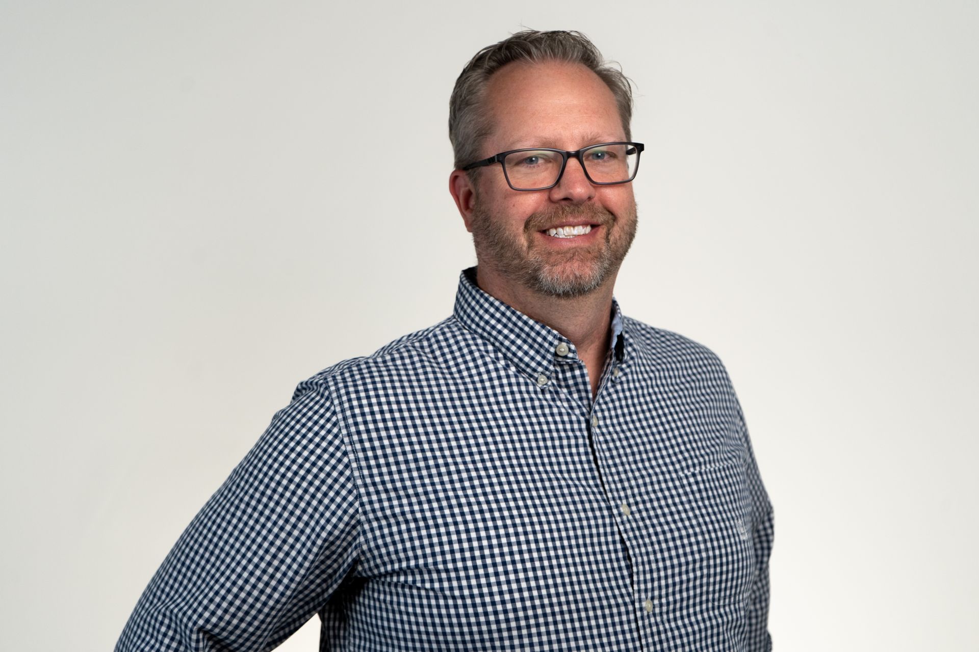 Man holding newborn baby in a hospital room, both wrapped in blankets.
