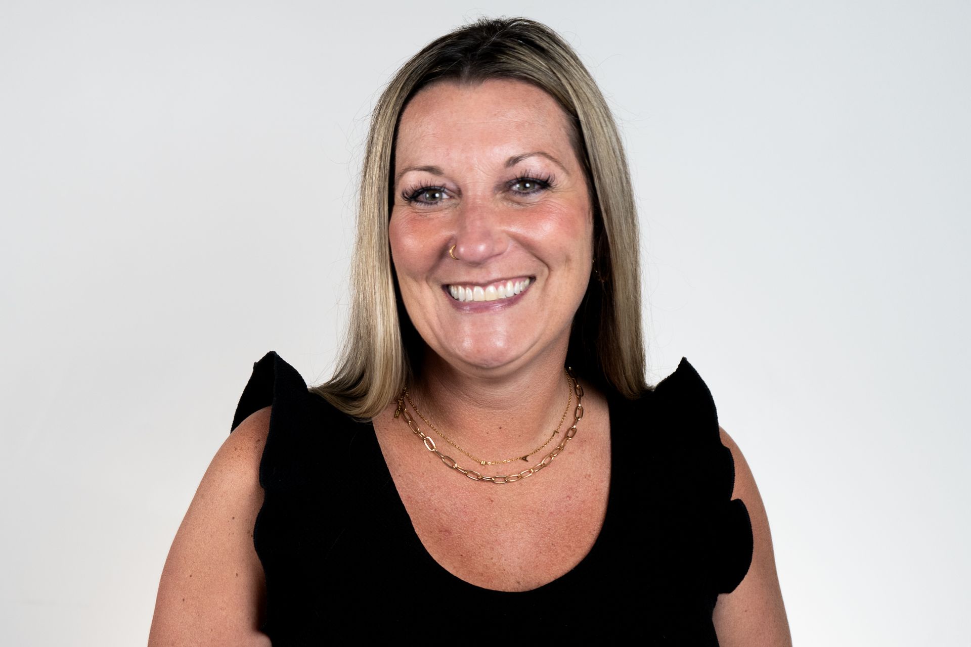 Family portrait: woman holding small dog, man in suit, children in formal wear, outdoor setting.