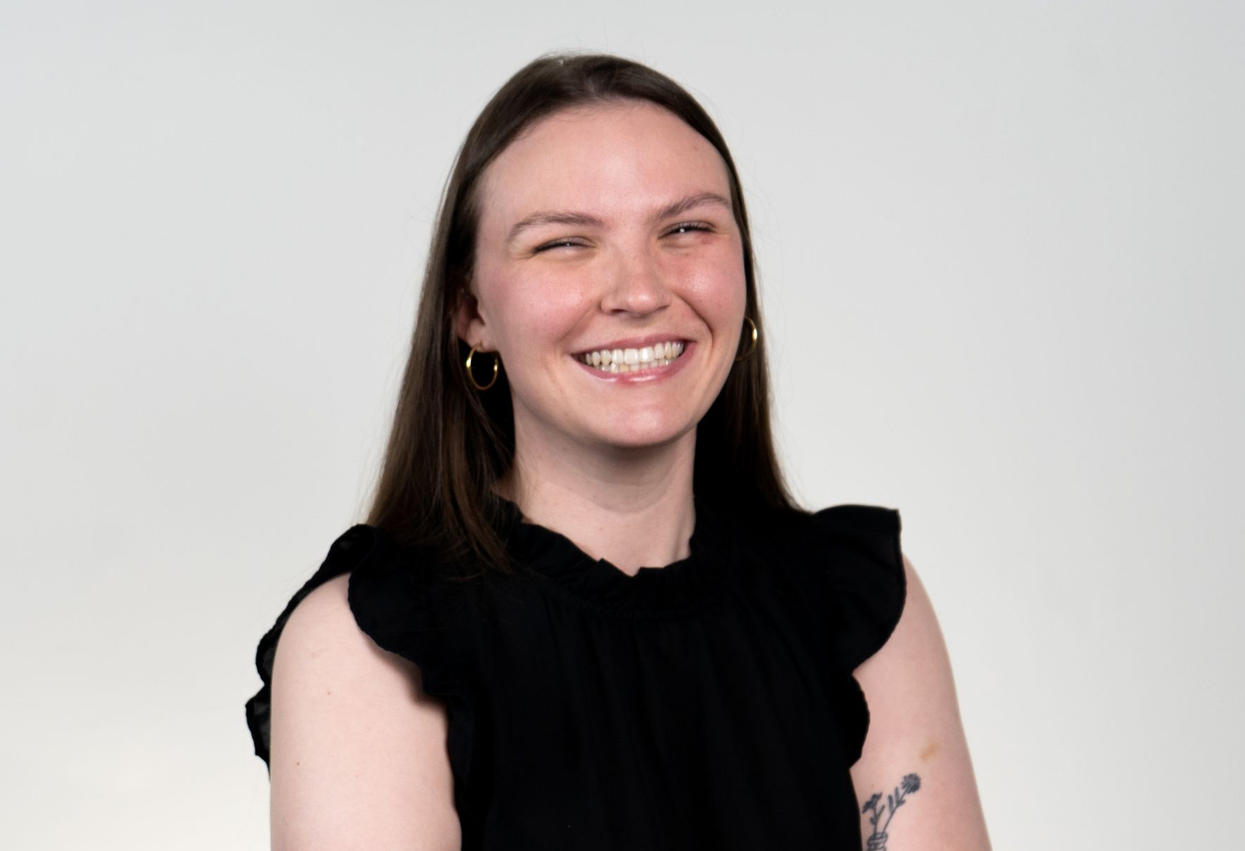 Family smiling indoors, man holding child. Blue shirts, warm lighting.