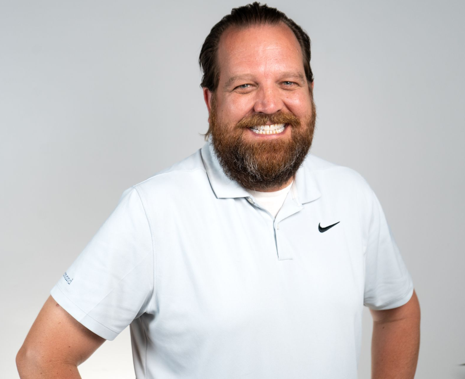 Three people wearing colorful headbands and shirts at a color run.