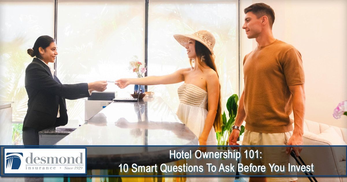 A hotel front desk scene: A receptionist hands a card to a woman in a hat, as a man stands beside her.