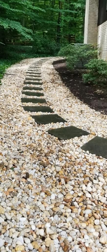 A walkway made of gravel and stepping stones leading to a house.