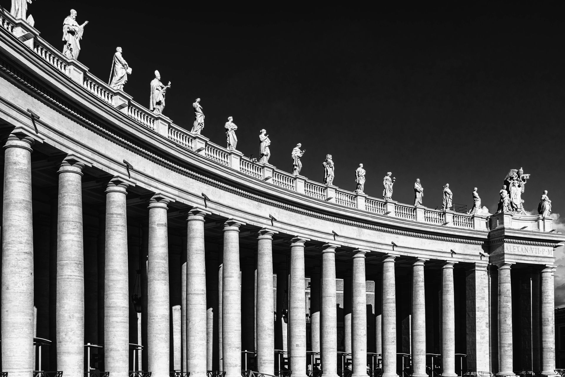 A black and white photo of a building with columns and statues