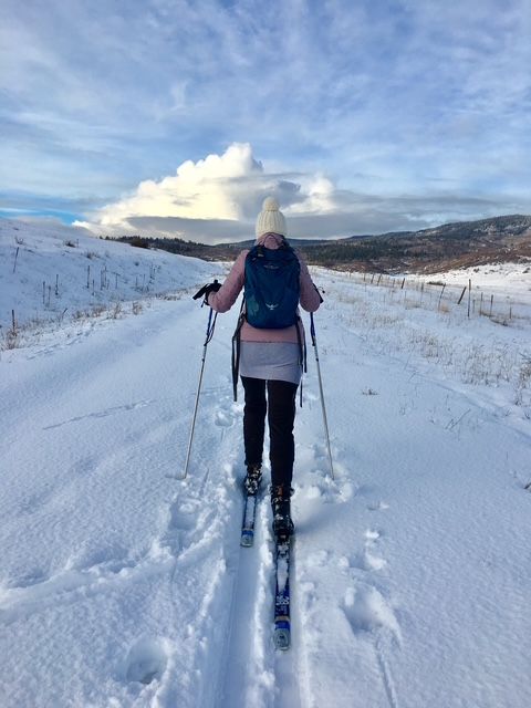 A person is skiing down a snow covered road.