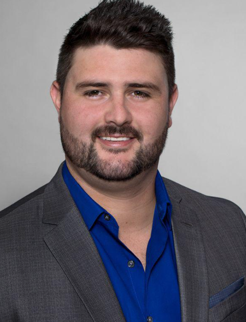 A man in a suit and tie is smiling for the camera.