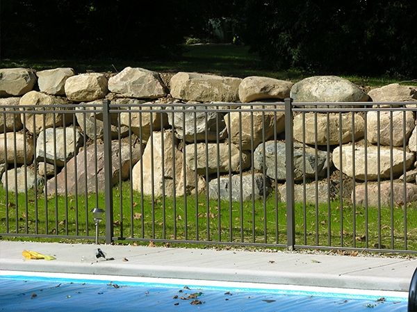 Pool Fence Near Natural Stone Retaining Wall — Chesterfield, MI — Radiance Aluminum Fence, Inc.