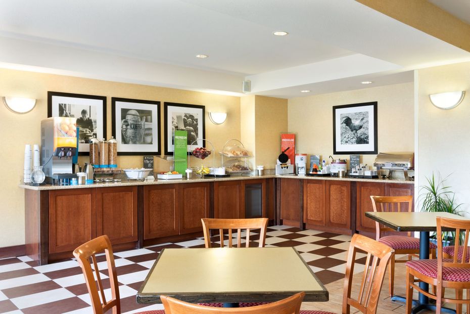 A restaurant with tables and chairs and a buffet