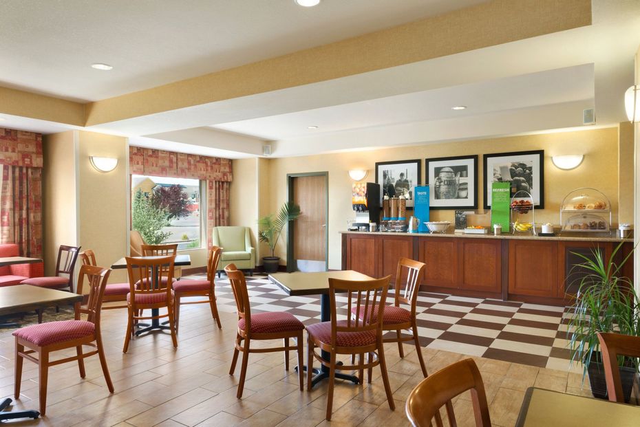 A restaurant with tables and chairs and a buffet
