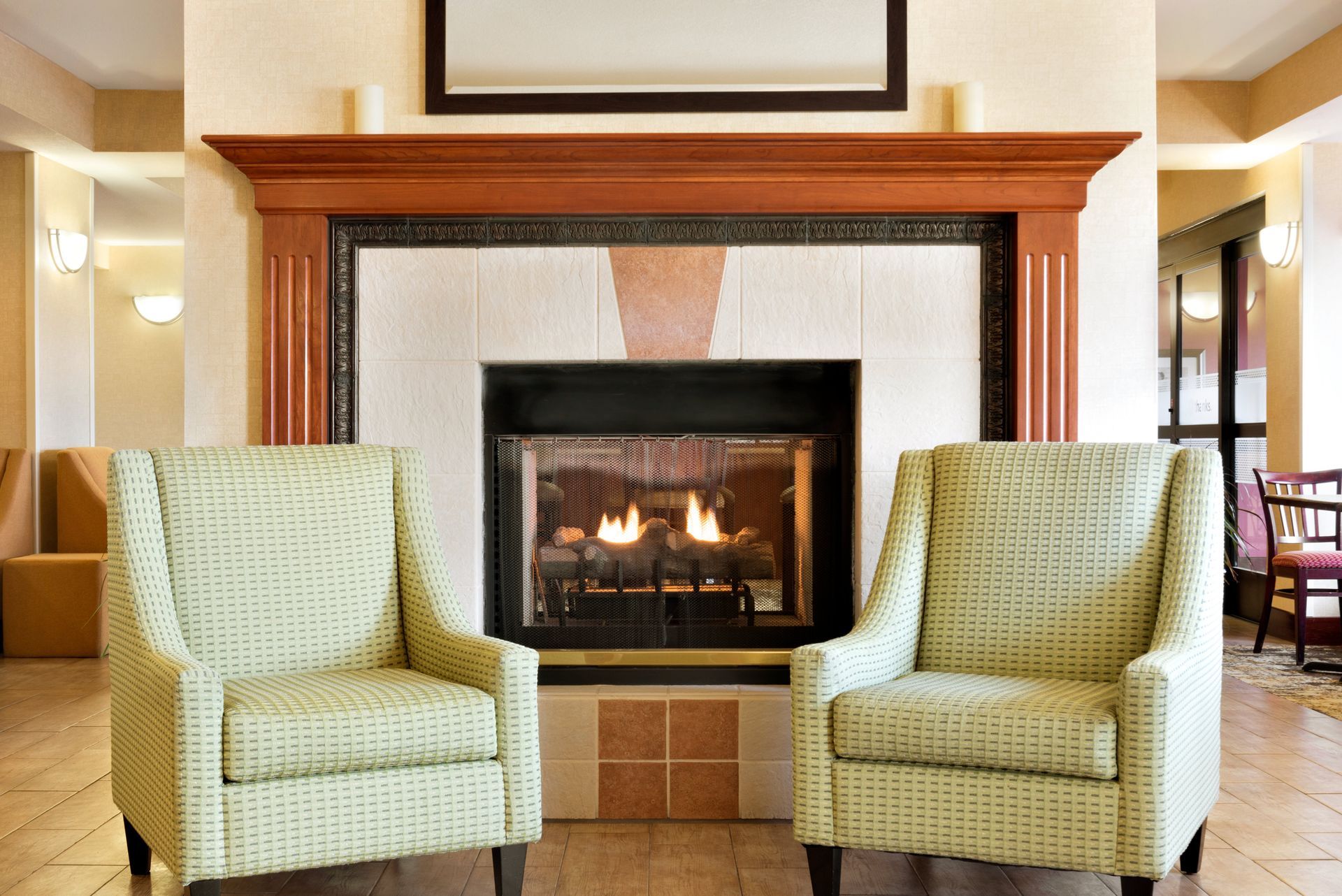 Two chairs in front of a fireplace in a hotel lobby