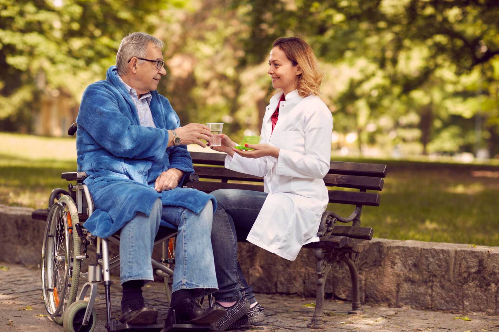 Elderly on a wheelchair with a nurse — Liberty, MO — Assured Healthcare