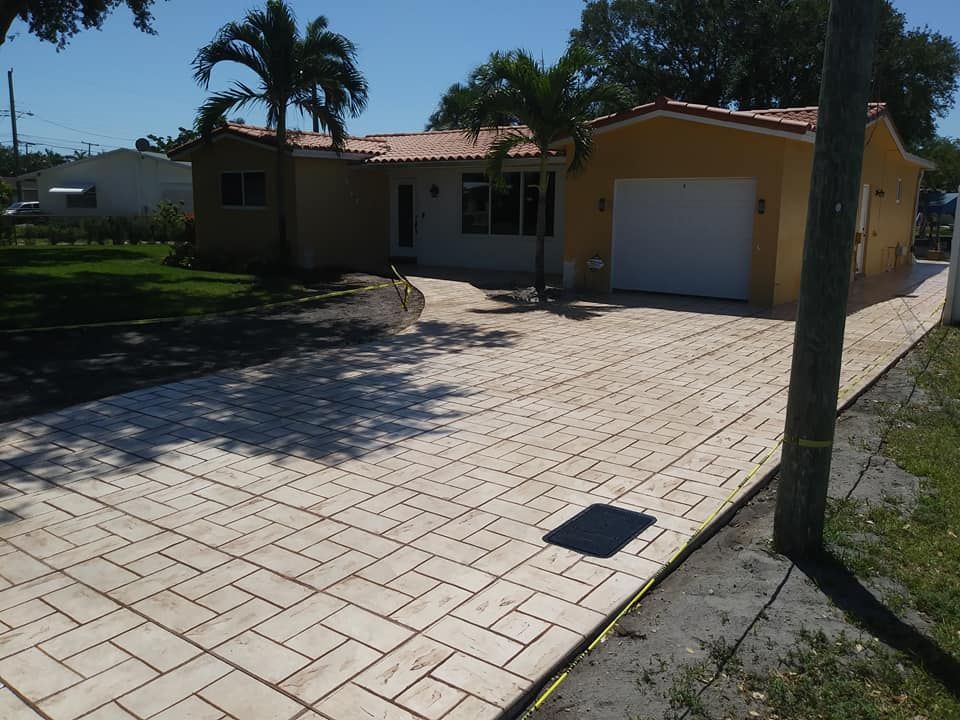 Metal grate drain in asphalt road, intersecting with white painted crosswalk lines.