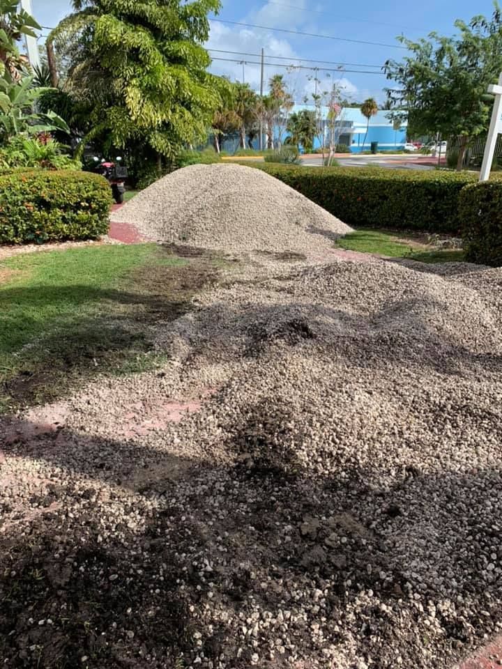 Large dump truck being loaded with rocks by a front-end loader at a quarry.