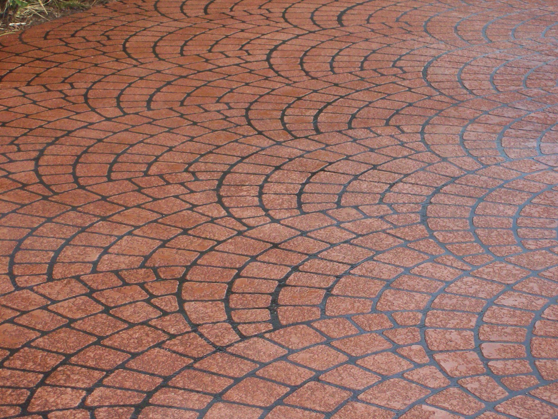 Red brick cobblestone ground with semi-circular patterns and dark grout.