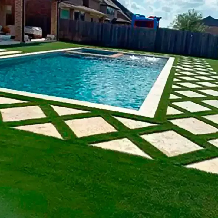 A large swimming pool surrounded by a lush green lawn in a backyard.