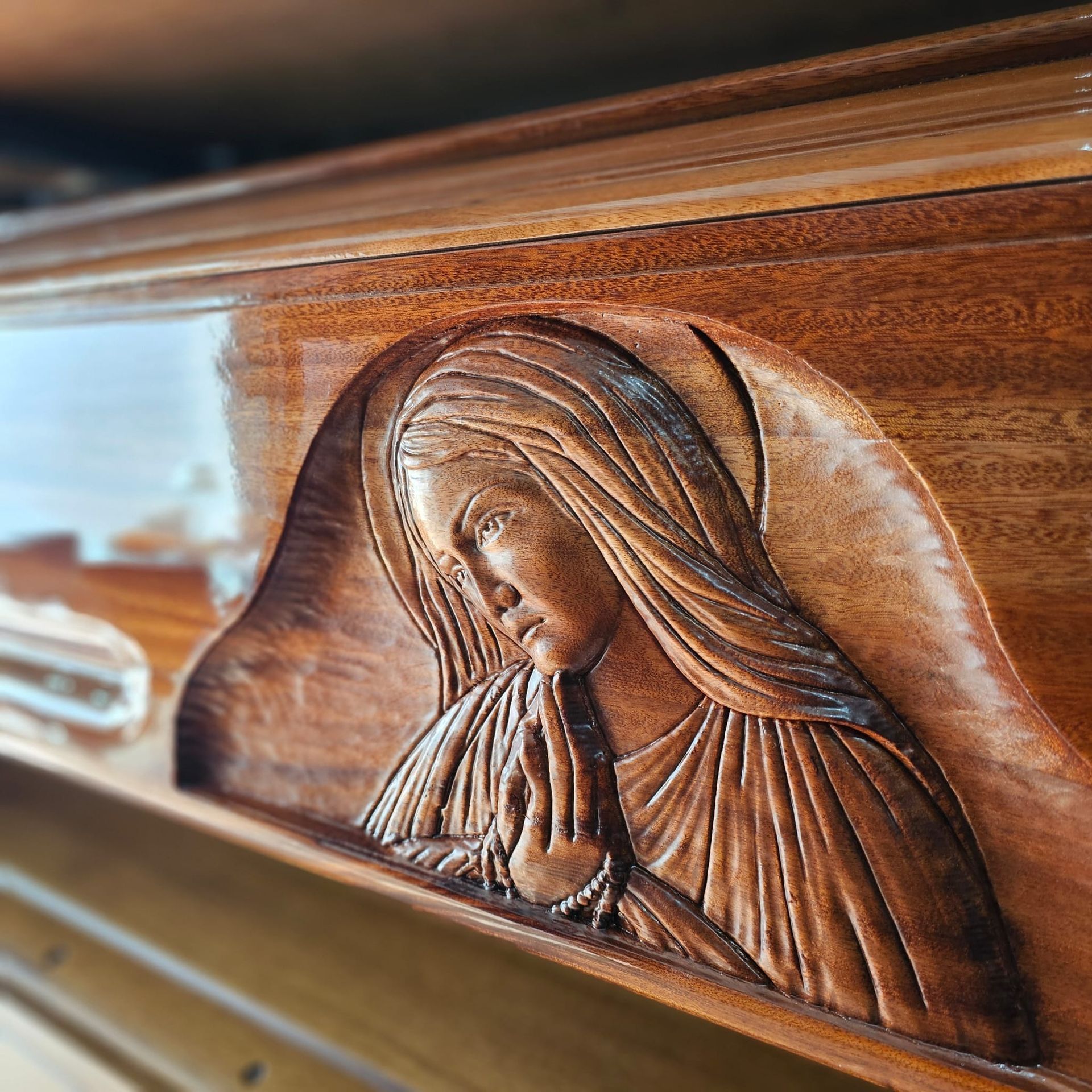 Rilievo in legno intagliato raffigurante una donna dall'espressione gentile, che indossa un copricapo drappeggiato e abiti.