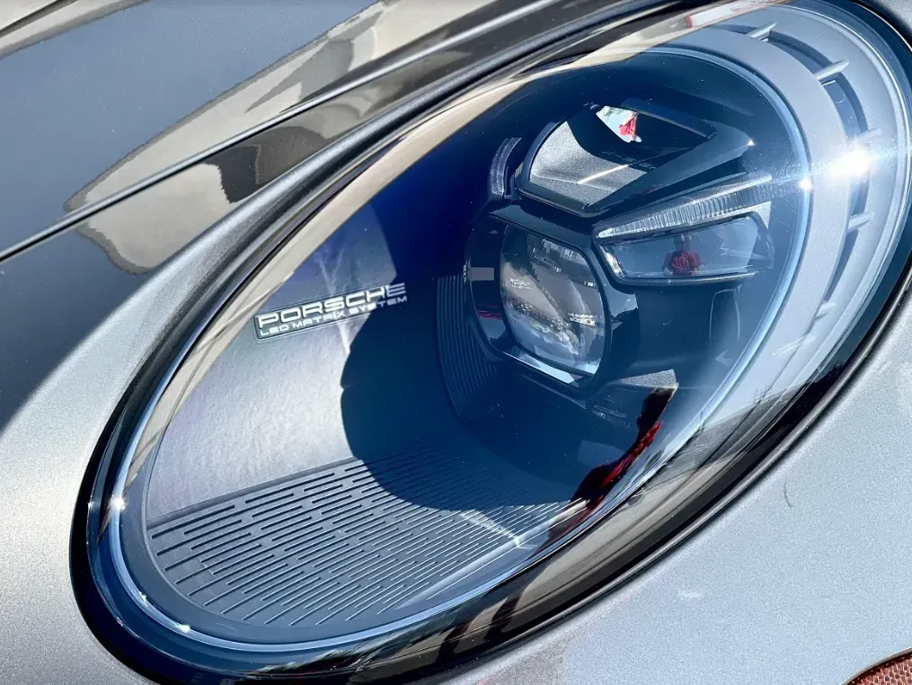 Close-up of a modern Porsche LED headlight with a silver grey finish and detailed interior lens technology.