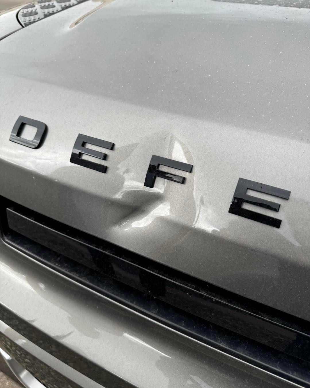 A silver car hood with black