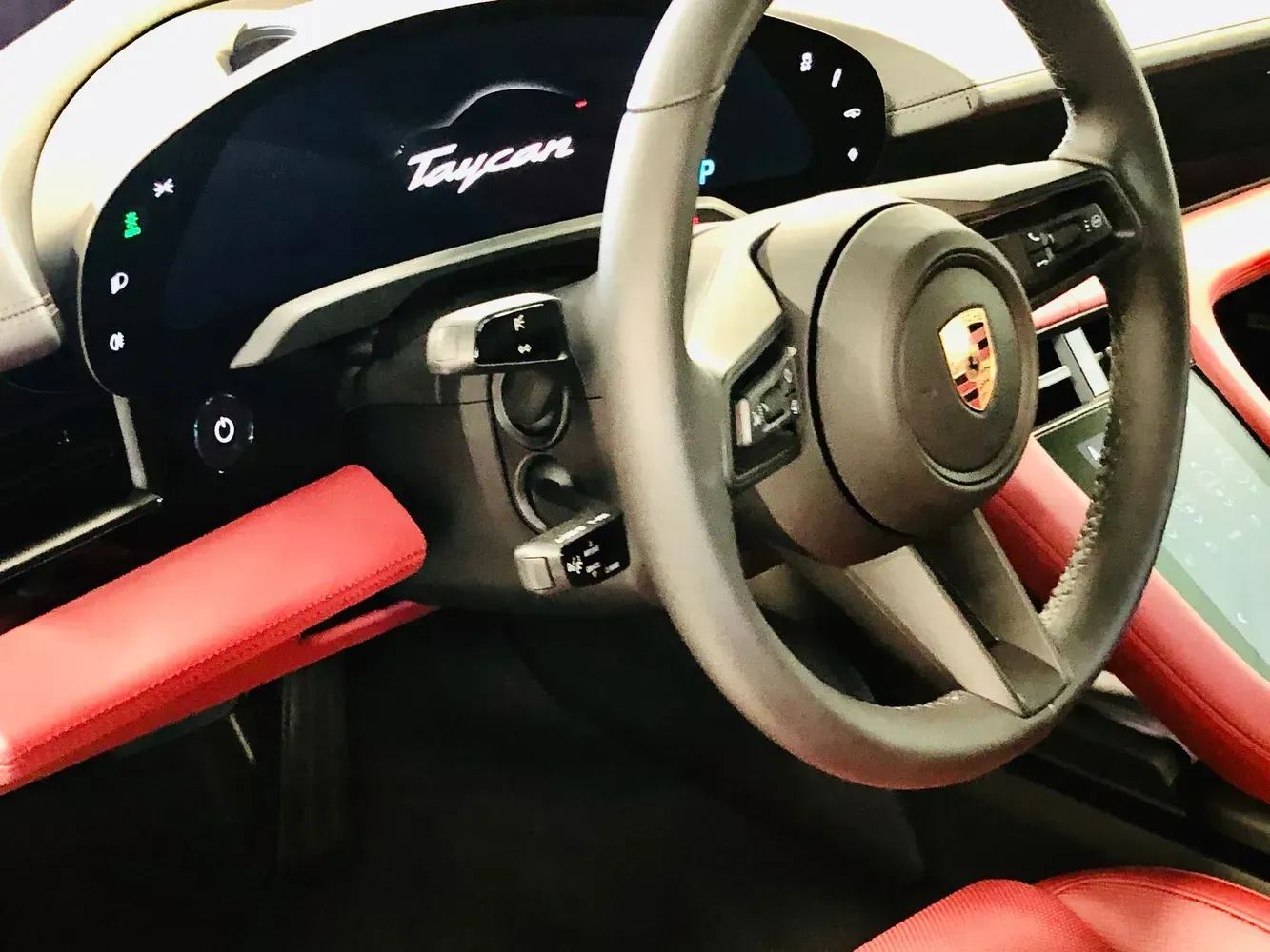 A car dashboard center console featuring a touchscreen head unit and controls, customized with a vibrant flame print.