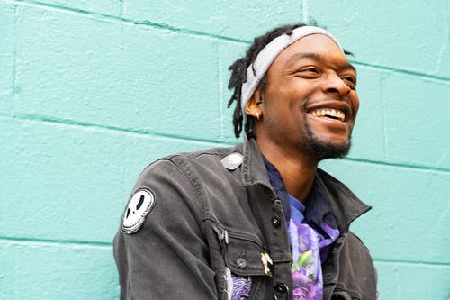 laughing man against turquoise wall