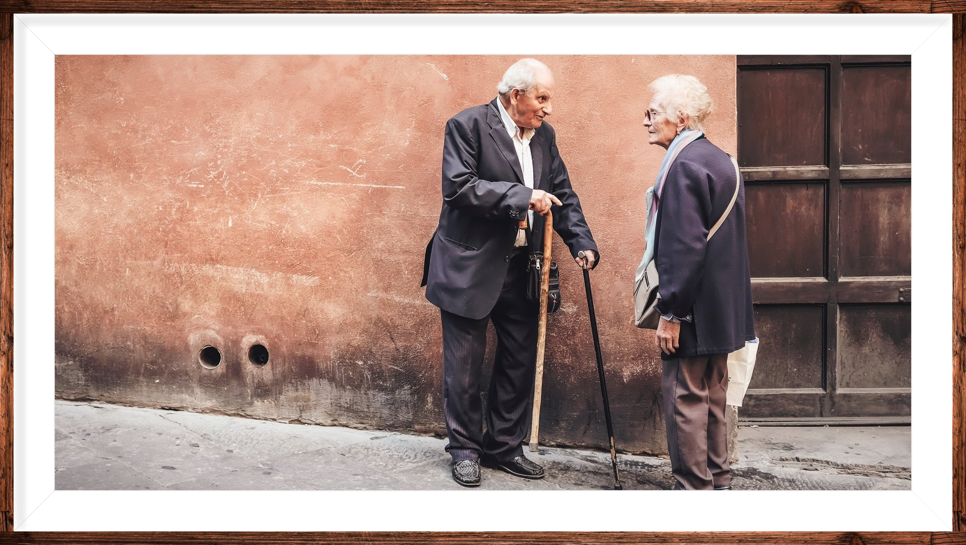 two older people chatting together standing outdoors