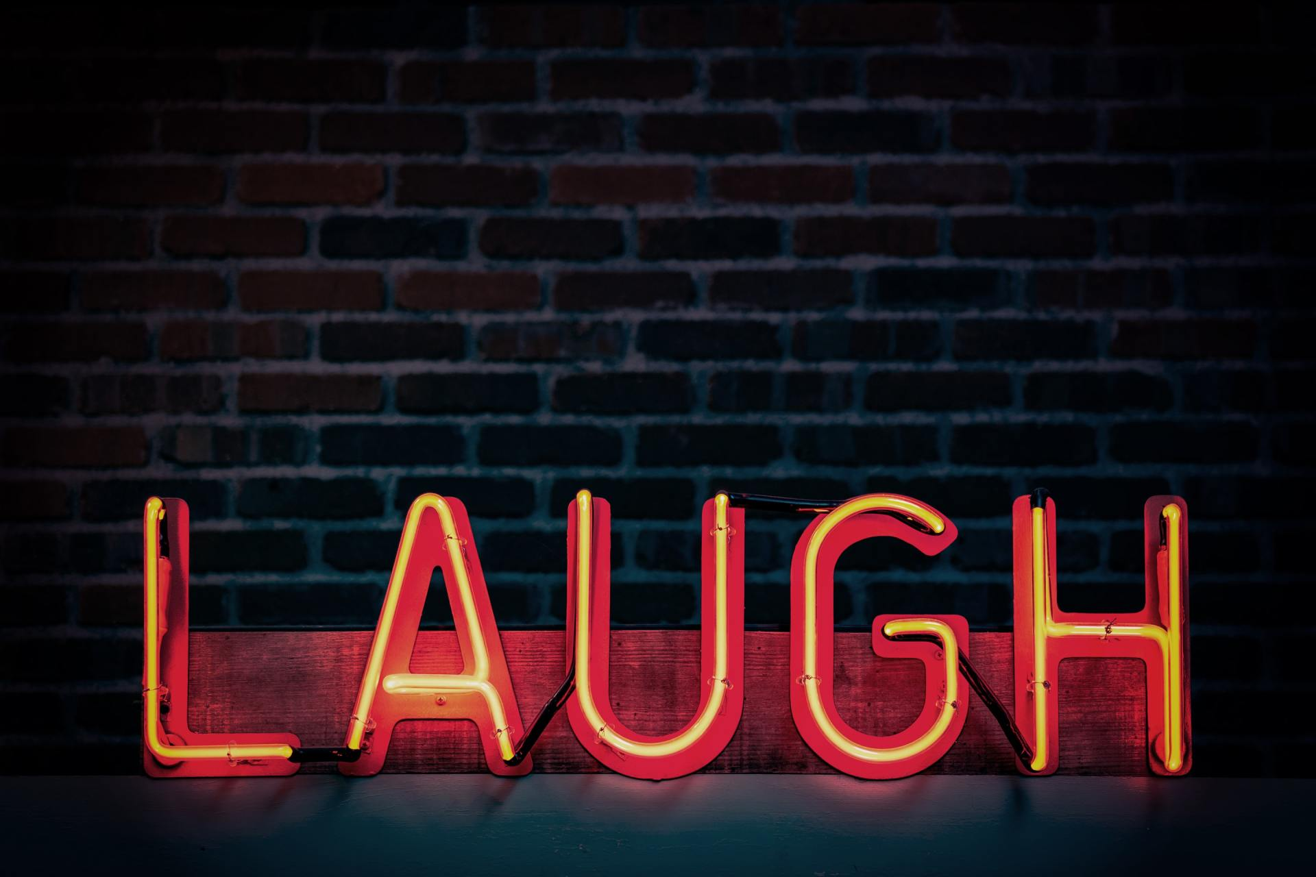 Neon sign LAUGH reminds us it is okay to laugh daily even about death!bout death.
