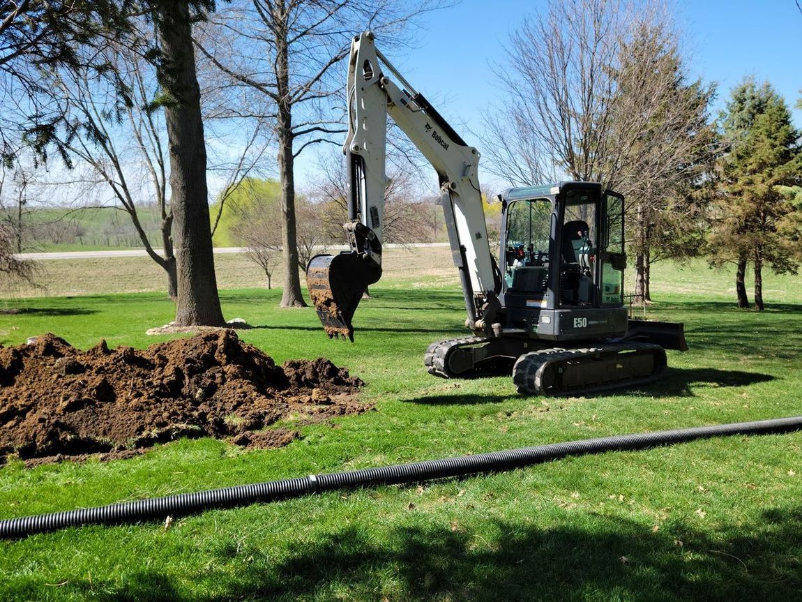 an excavator is digging a hole in the grass in a park