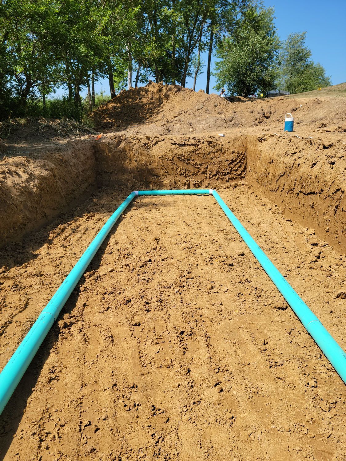 a hole in the ground with a blue pipe in it