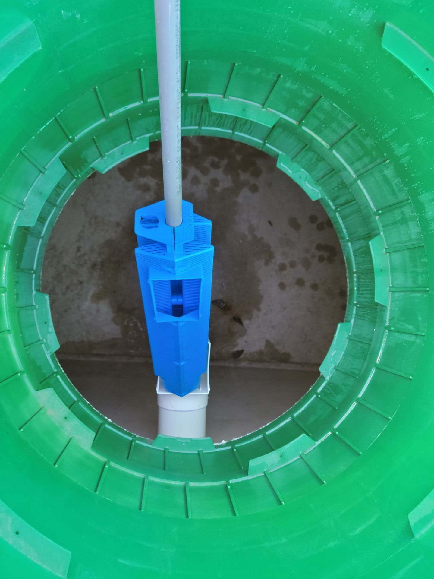 a green hose is connected to a hole in the ground