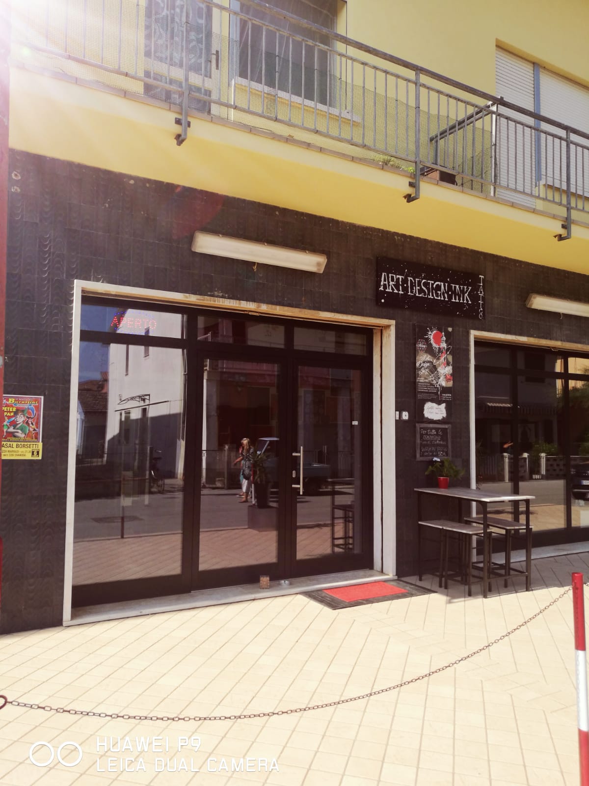 ingresso di un'attività con porta a specchio a tre ante