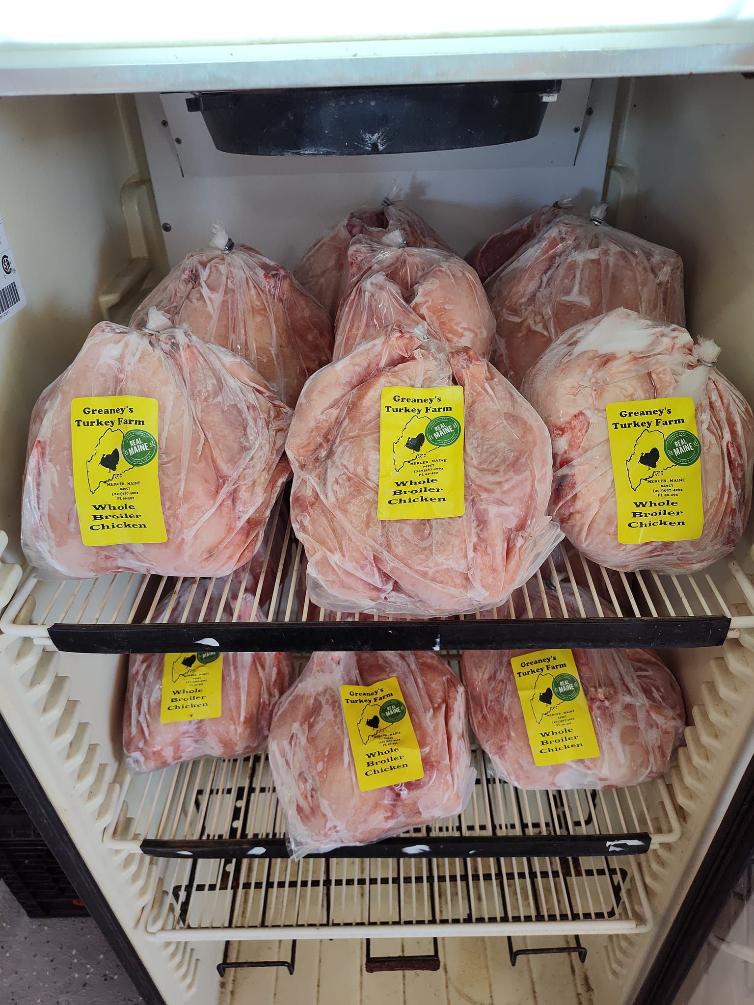 Frozen meat packages in a refrigerator. Yellow labels visible.
