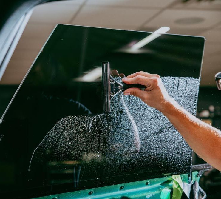 A group of people are working on a car in a garage.