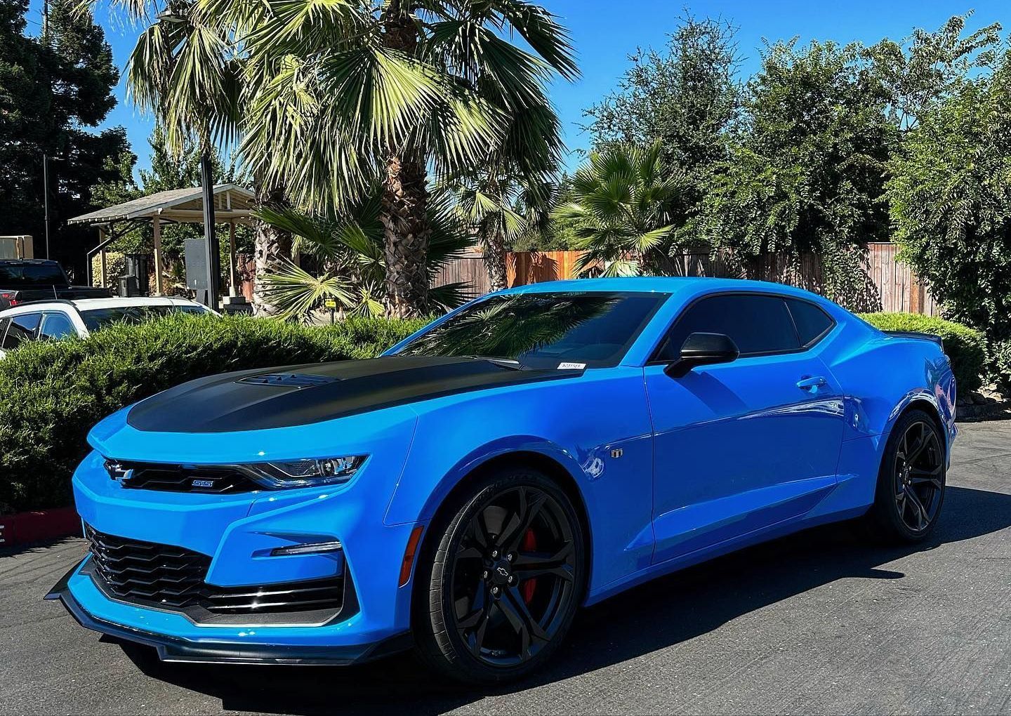 A blue chevrolet camaro is parked in a parking lot.