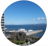 A circle with a view of a city and a body of water.