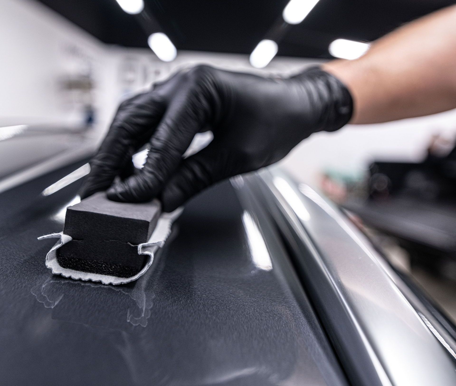 An orange sports car is parked in front of a palm tree.