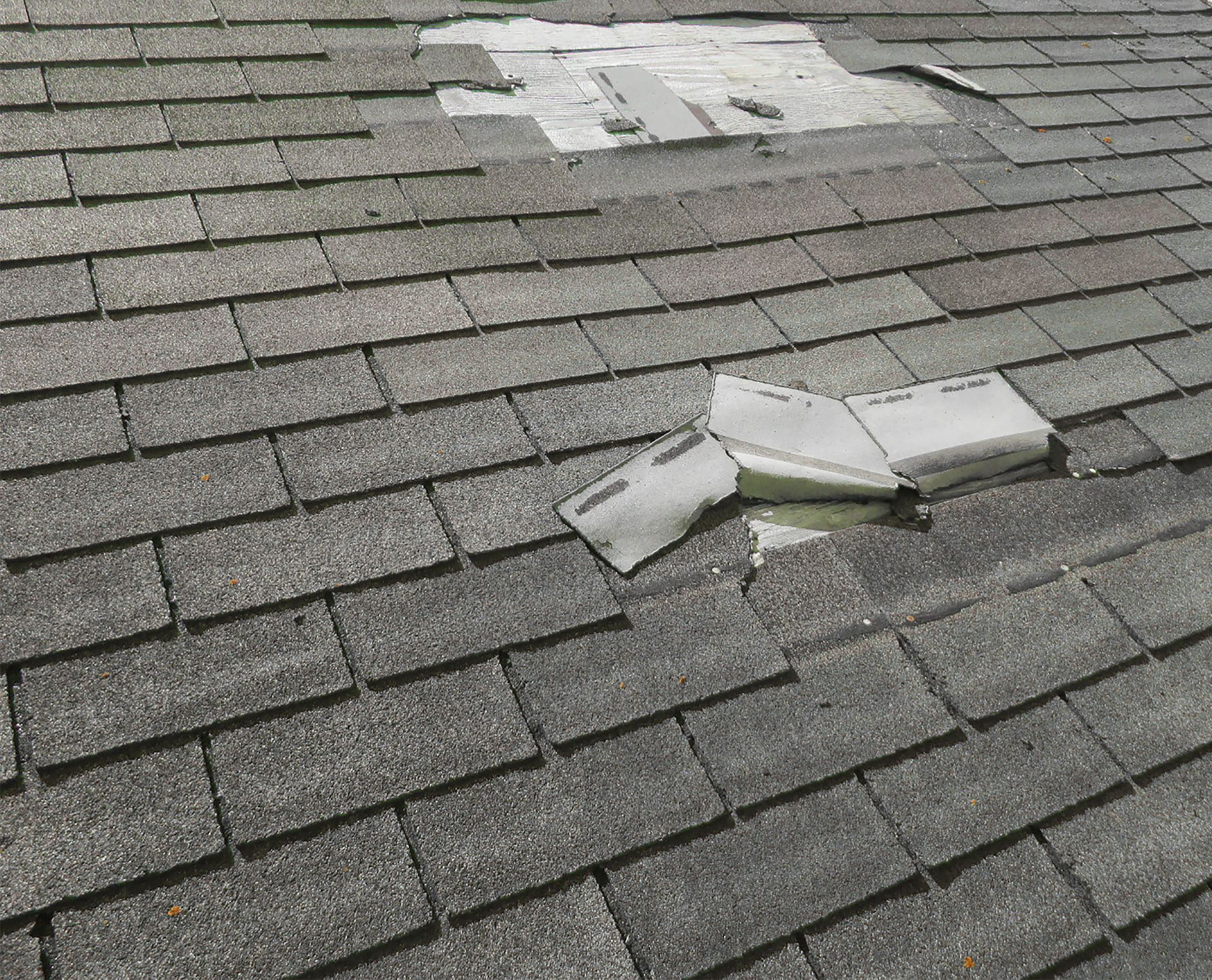 A roof with a hole in it and a piece of paper on it.