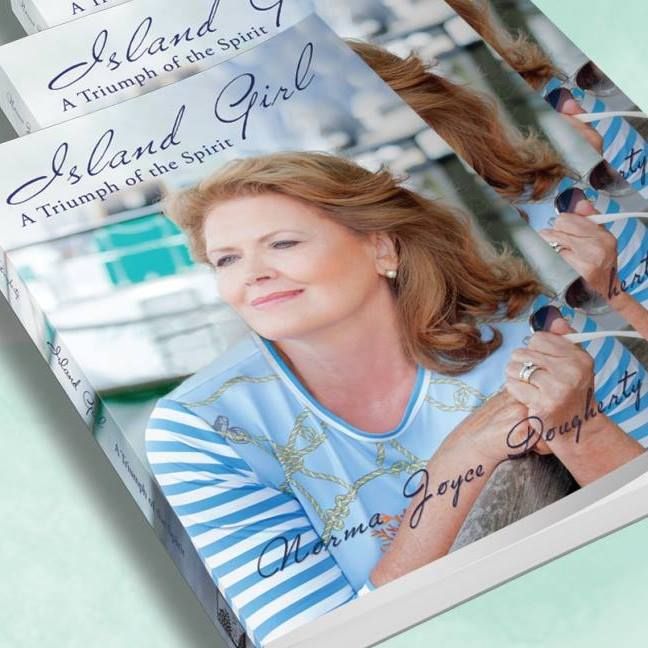 Stack of books titled “Island Girl” featuring a smiling woman in a blue-striped shirt on the cover