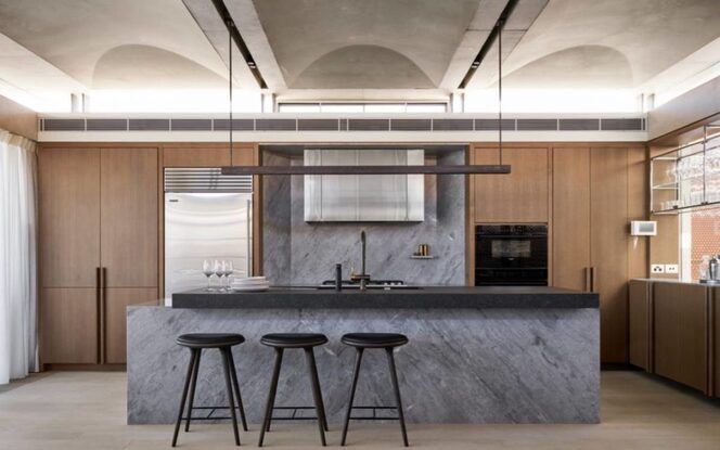 A kitchen with a large island and three stools