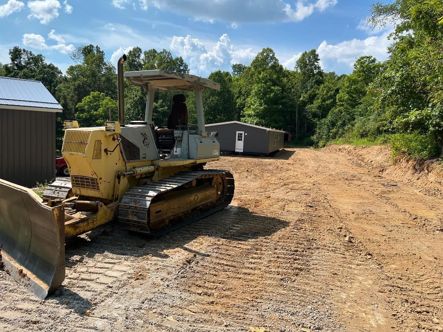A bulldozer is sitting in the middle of a dirt field.