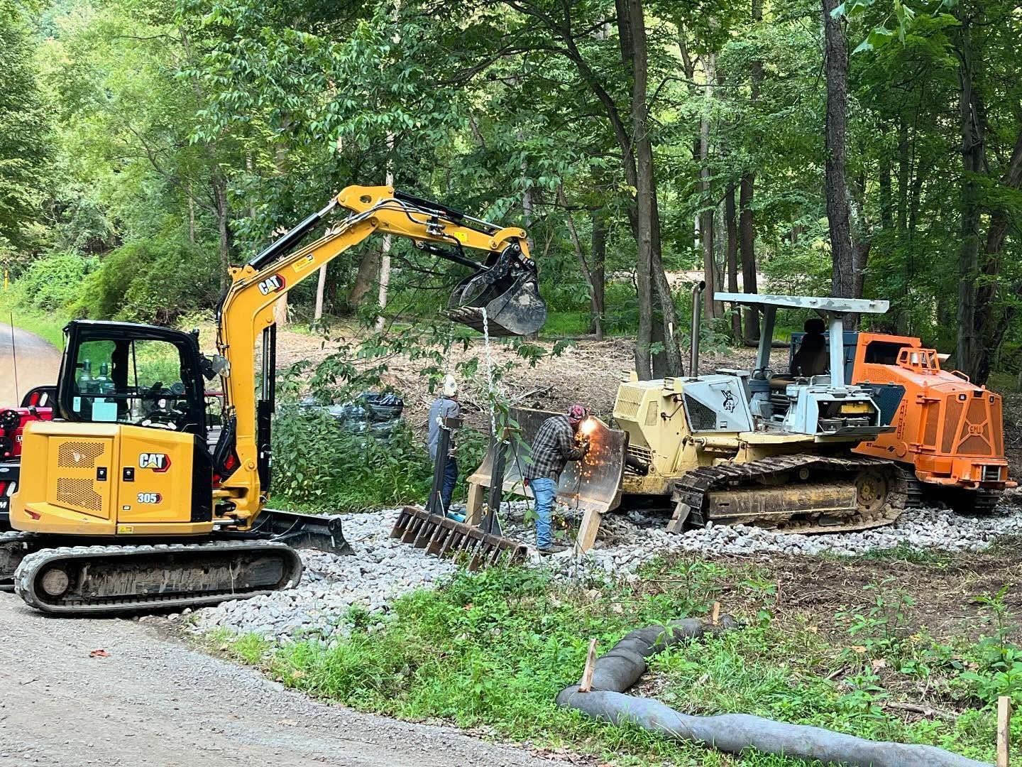 A couple of construction vehicles are parked on the side of a road.