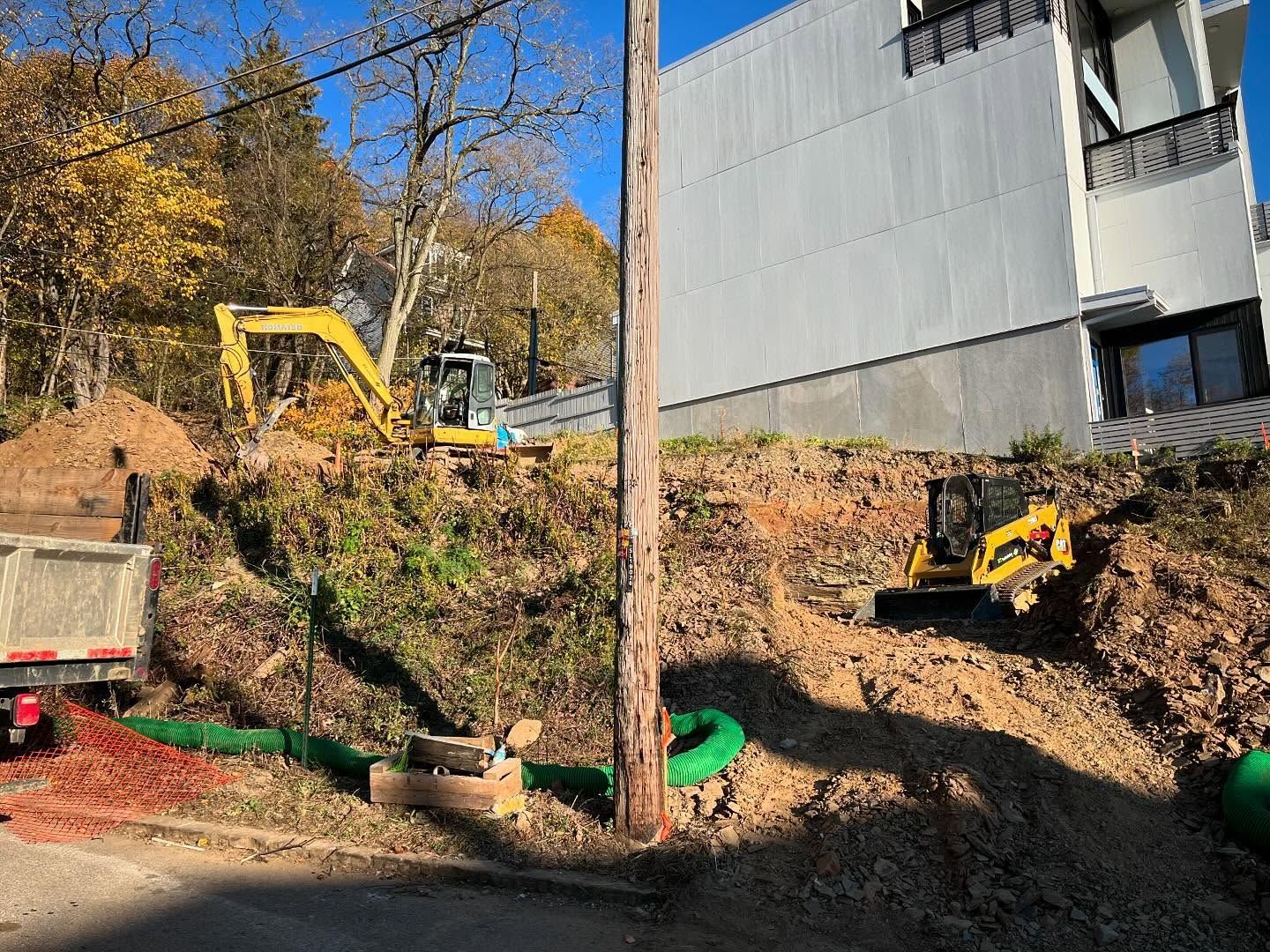 A construction site with a lot of dirt and a building in the background.